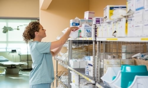 A nurse searches shelves for items in a hospital