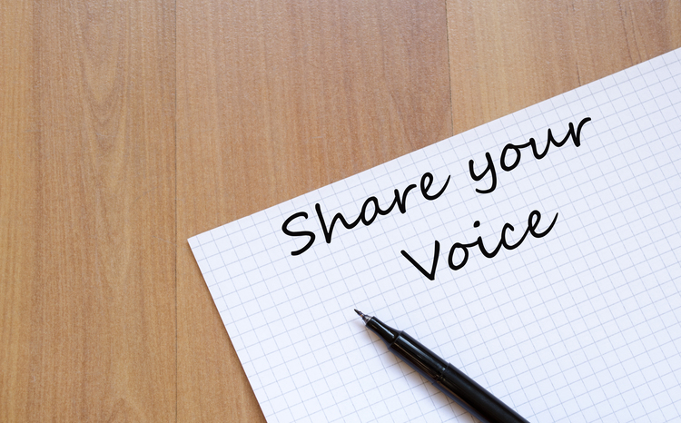 Piece of paper with share your voice written on it